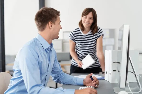 Kollegen im Gespräch im Büro – Symbol für die Erstellung der Vorschlagsliste zur Betriebsratswahl.